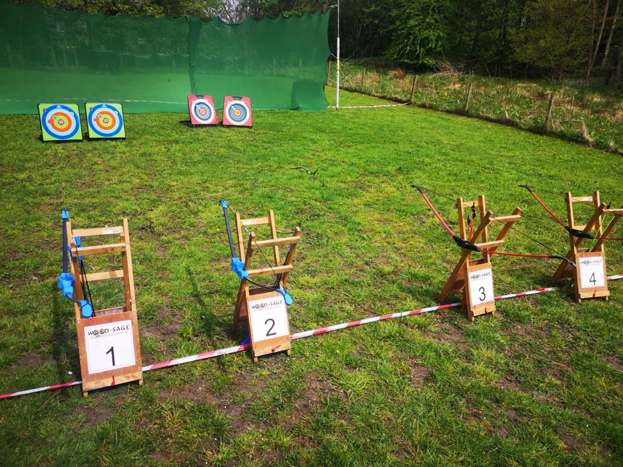 Soft archery equipment set up and ready for use, including a bow, suction-cup arrows, and a colourful target