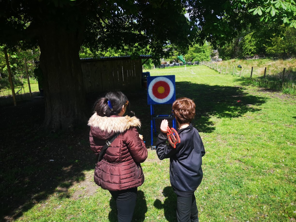 Soft axe throwing game set up with plastic axes and a bristle target board, designed for safe indoor or outdoor play