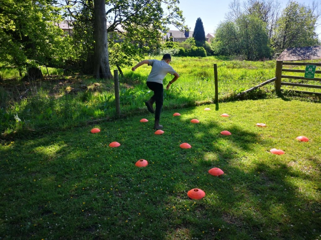 Children playing high-energy outdoor games at a birthday party, running, laughing, and participating in team challenges on a grassy field.