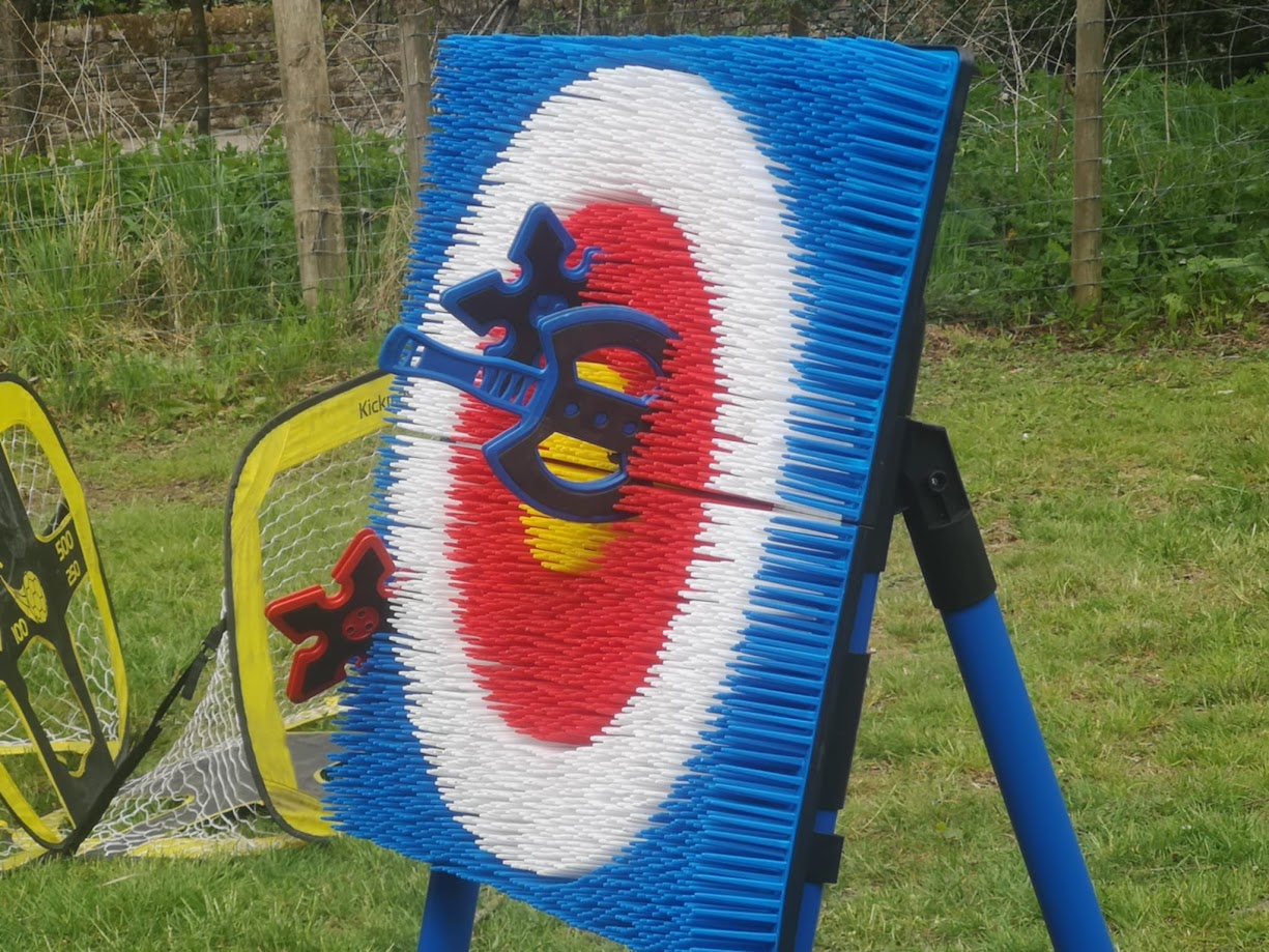 Soft axe throwing game set up with plastic axes and a bristle target board, designed for safe indoor or outdoor play