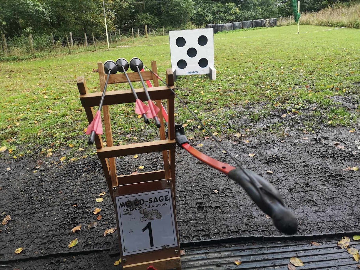 Soft archery setup featuring a bow with foam-tipped arrows aimed at punch-out style targets on a stand, designed for safe play