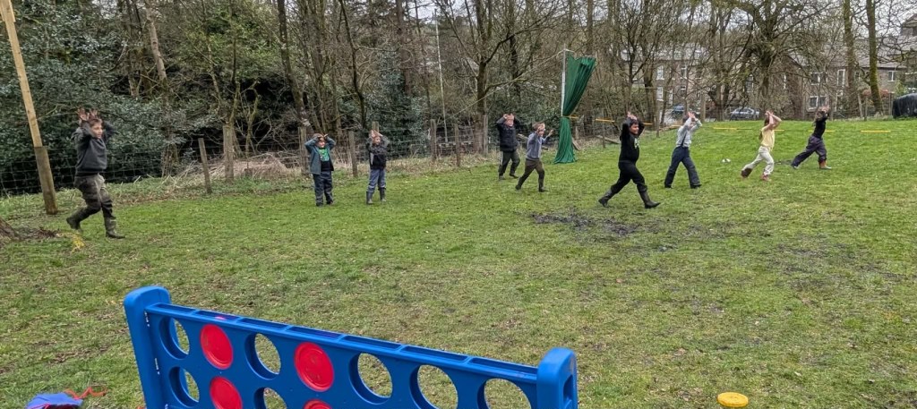 “Children enjoying a fun outdoor activity during the Easter HAF 2026 programme at Wood‑Sage Outdoor Education, with a giant Connect Four game in the foreground.