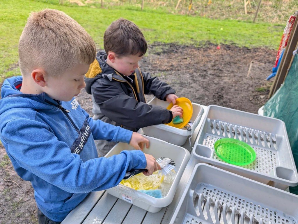 Children washing dishes outdoors during Easter HAF 2026 at Wood‑Sage Outdoor Education.