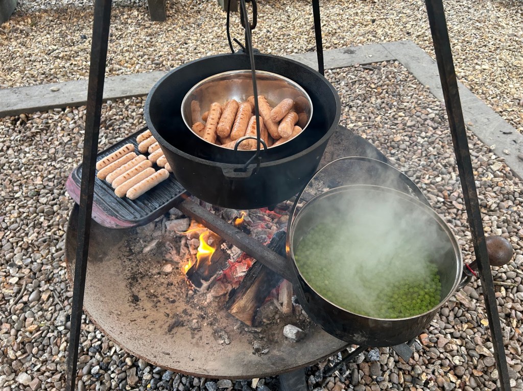 Campfire meal of sausages, mashed potato and peas served during Easter HAF 2026 at Wood‑Sage Outdoor Education.